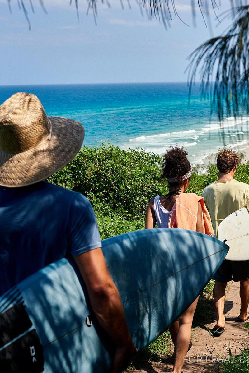 Group of friends heading th the beach with surfboards, forest trail following the coast. All rights reserved, Corona Instagram, exclusive content.