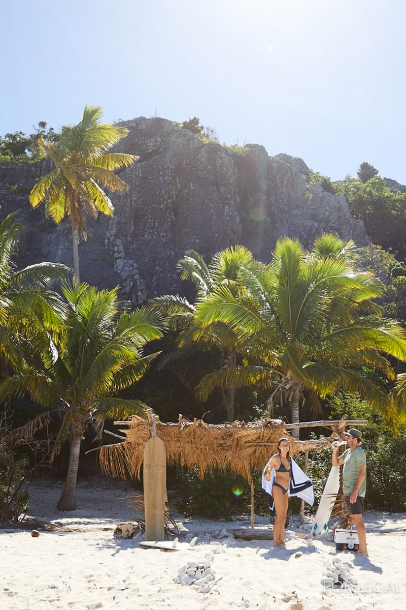 Palm leaves bangalo, couple drinking beer on white sand. All rights reserved, Corona Instagram, exclusive content.