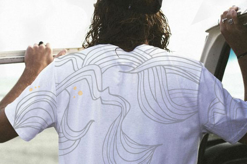 Long haired guy backwards in a car, printed shirt.