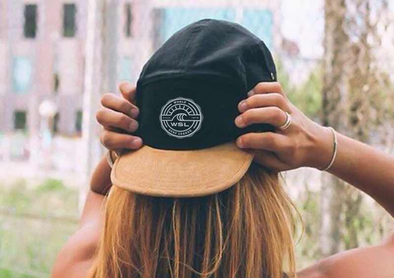 Woman wearing black and suede brown cap with WSL logo.