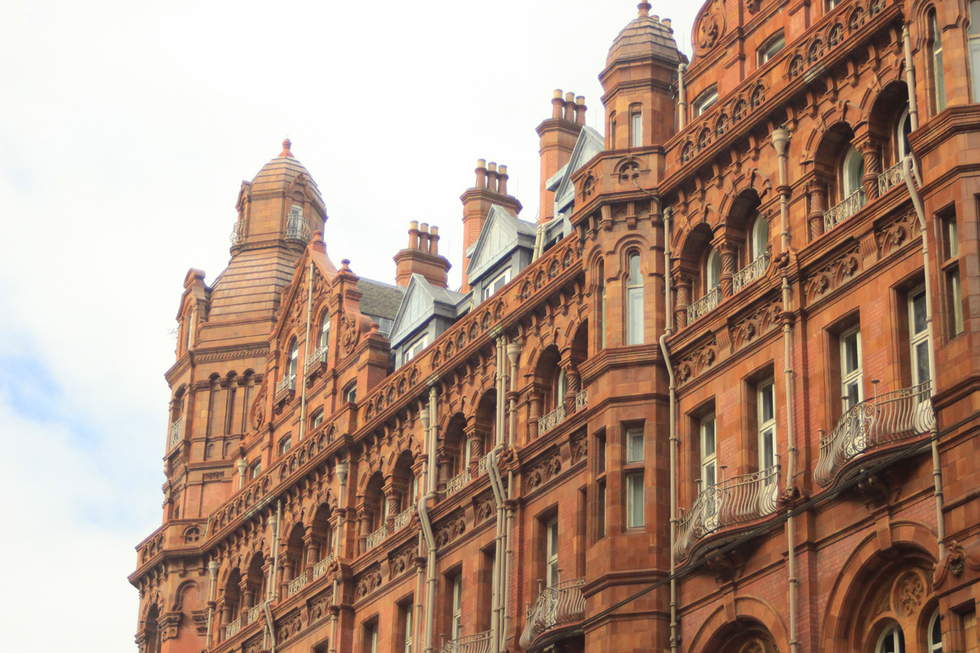 Manchester building, red and maroon tiles. Balconies and towers. Factory like architecture. Photo sold on Creative Market.